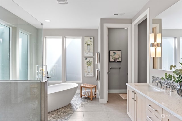 bathroom featuring tile patterned flooring, a bath, and vanity