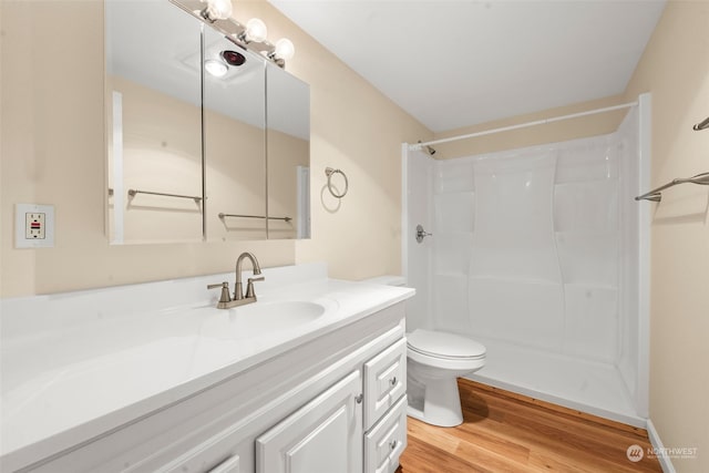 bathroom featuring hardwood / wood-style flooring, vanity, toilet, and a shower