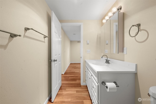 bathroom with vanity, wood-type flooring, and toilet