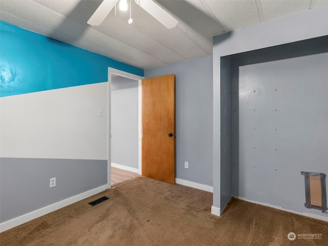 unfurnished room with carpet flooring and ceiling fan