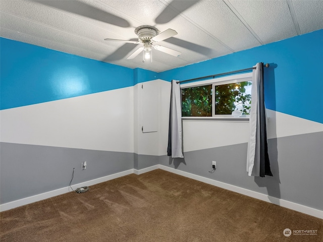 carpeted empty room featuring ceiling fan and a textured ceiling