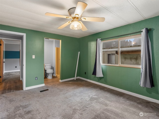 unfurnished bedroom with carpet, ceiling fan, a textured ceiling, and ensuite bath