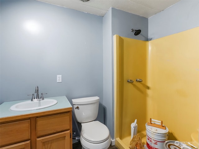 bathroom with vanity, toilet, and a shower