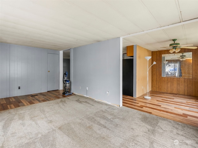 spare room featuring ceiling fan, wood walls, and hardwood / wood-style flooring