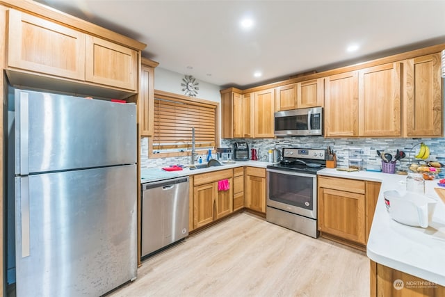 kitchen featuring backsplash, light wood-type flooring, and stainless steel appliances