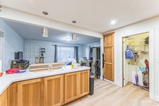 kitchen featuring decorative light fixtures and light hardwood / wood-style flooring