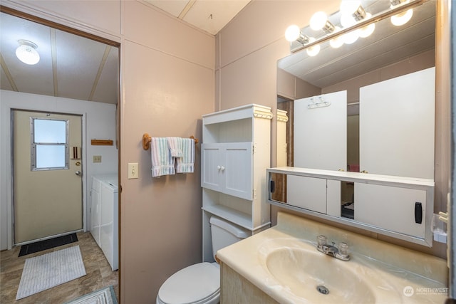 bathroom with independent washer and dryer, vanity, and toilet