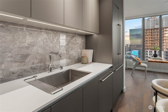 kitchen featuring dark hardwood / wood-style floors, tasteful backsplash, gray cabinetry, and sink