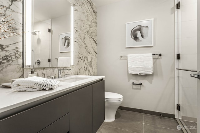 bathroom featuring toilet, vanity, tile patterned floors, and a shower with shower door