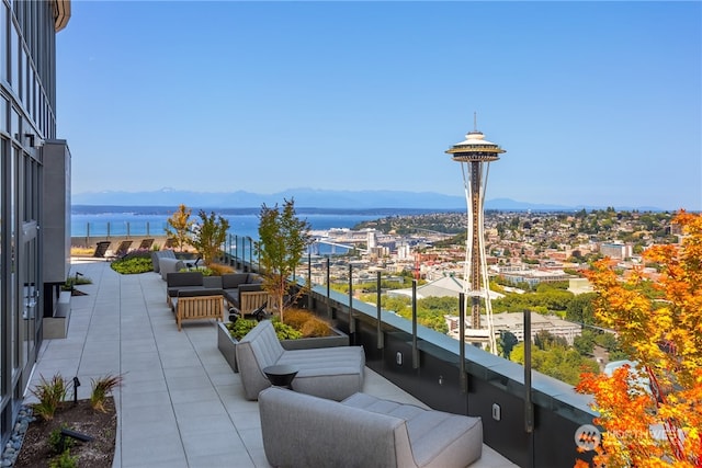 balcony featuring an outdoor living space and a water and mountain view