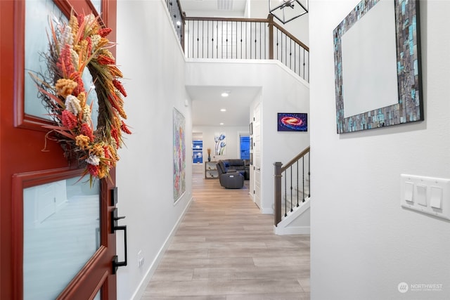 foyer featuring a towering ceiling and light hardwood / wood-style flooring