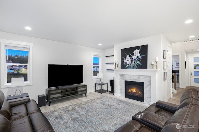 living room featuring a high end fireplace and wood-type flooring