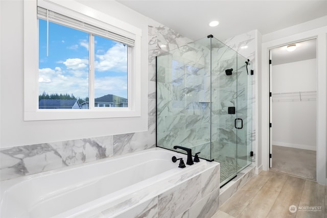 bathroom with hardwood / wood-style floors and shower with separate bathtub