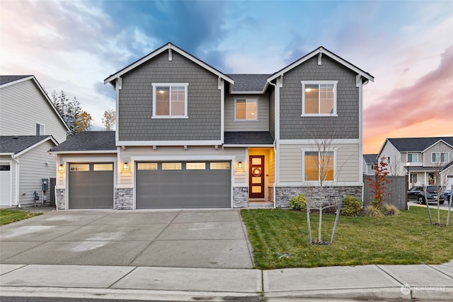 craftsman inspired home featuring a lawn and a garage