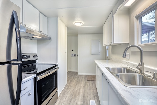 kitchen featuring appliances with stainless steel finishes, light wood-type flooring, white cabinetry, and sink