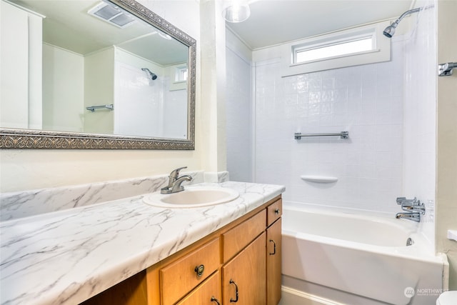 bathroom featuring vanity and tiled shower / bath