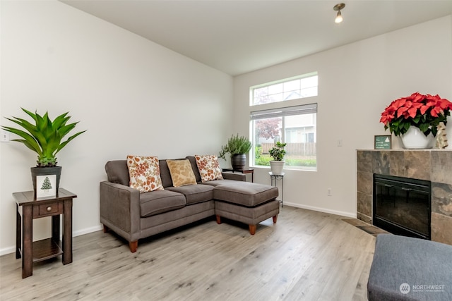 living room featuring light hardwood / wood-style floors and a tile fireplace