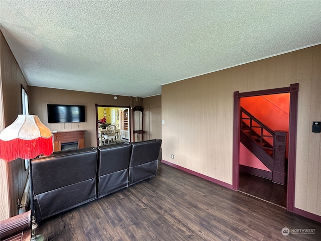 living room with a textured ceiling and dark hardwood / wood-style floors