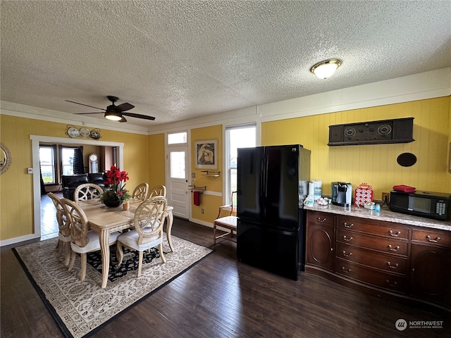 dining room with ceiling fan, crown molding, dark wood-type flooring, and a textured ceiling