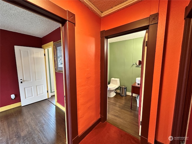 hallway with dark hardwood / wood-style flooring and a textured ceiling