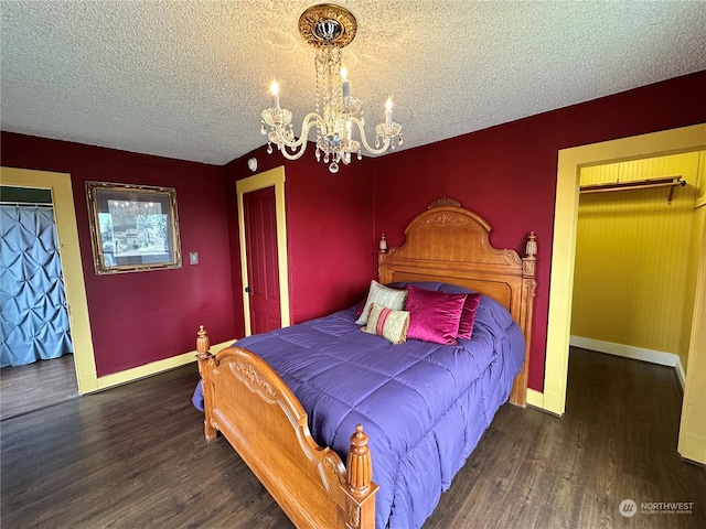 bedroom featuring a textured ceiling, a closet, dark wood-type flooring, and an inviting chandelier