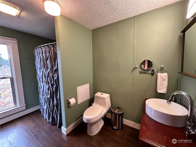 bathroom with hardwood / wood-style flooring, curtained shower, toilet, and a textured ceiling