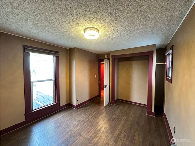 unfurnished bedroom with a closet, dark wood-type flooring, and a textured ceiling