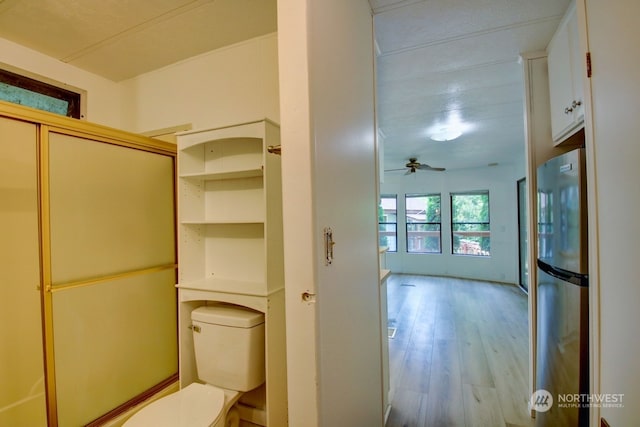 bathroom featuring ceiling fan, wood-type flooring, and toilet