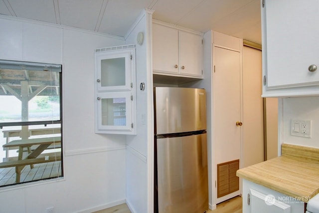 kitchen featuring white cabinets, light hardwood / wood-style floors, and stainless steel refrigerator