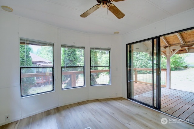 unfurnished sunroom featuring plenty of natural light and ceiling fan