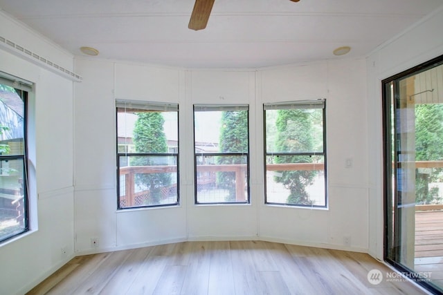 spare room with ceiling fan, plenty of natural light, and light wood-type flooring