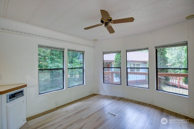 unfurnished room with light hardwood / wood-style flooring, plenty of natural light, and ceiling fan