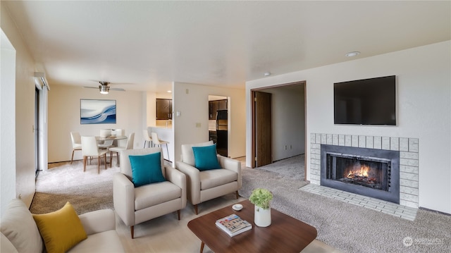 carpeted living room featuring a fireplace and ceiling fan