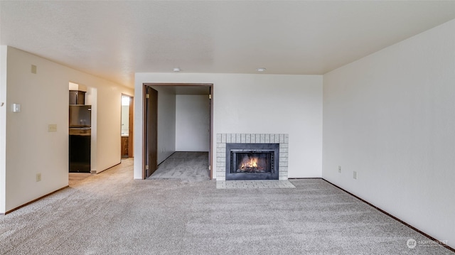 unfurnished living room featuring light carpet and a fireplace