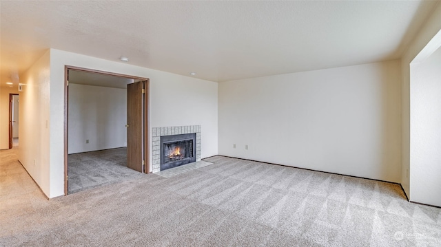 unfurnished living room with light carpet and a fireplace