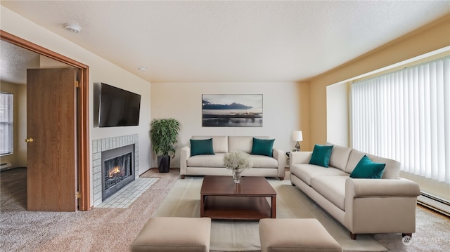 living room featuring light carpet, a textured ceiling, a baseboard radiator, and a healthy amount of sunlight