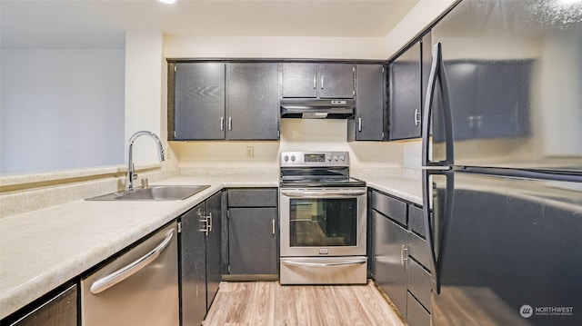 kitchen with stainless steel appliances, light hardwood / wood-style floors, and sink