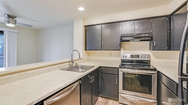 kitchen with ceiling fan, sink, light wood-type flooring, and stainless steel appliances