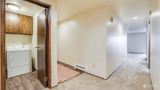 clothes washing area with cabinets, light carpet, washer / clothes dryer, and a baseboard radiator