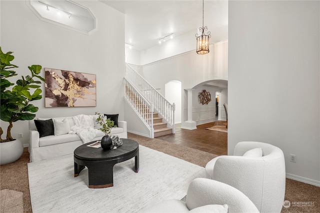 carpeted living room with track lighting and decorative columns