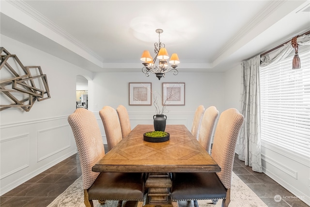 dining space featuring a raised ceiling, crown molding, and a notable chandelier