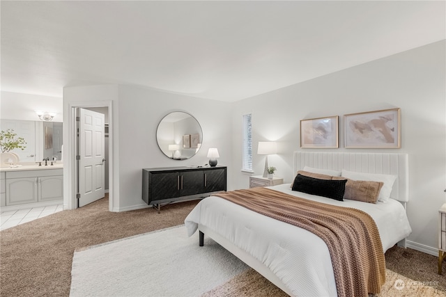 carpeted bedroom with sink and ensuite bath