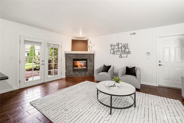 living room with hardwood / wood-style flooring and a tiled fireplace