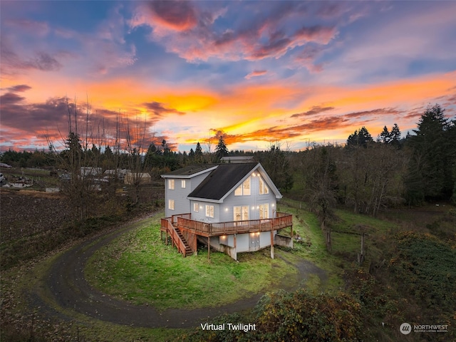 back house at dusk featuring a deck