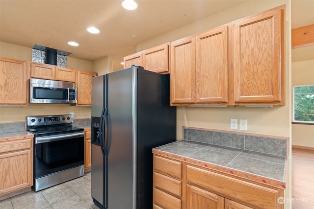 kitchen featuring light brown cabinetry, stainless steel appliances, and light hardwood / wood-style flooring