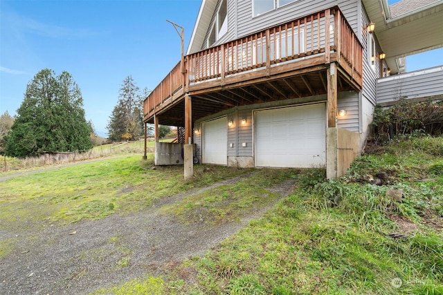 exterior space with a garage, a lawn, and a wooden deck