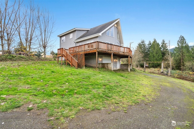 rear view of house with a deck and a lawn