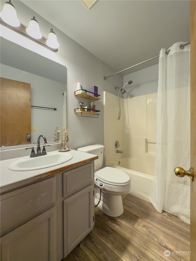 full bathroom with hardwood / wood-style floors, toilet, vanity, and shower / tub combo with curtain