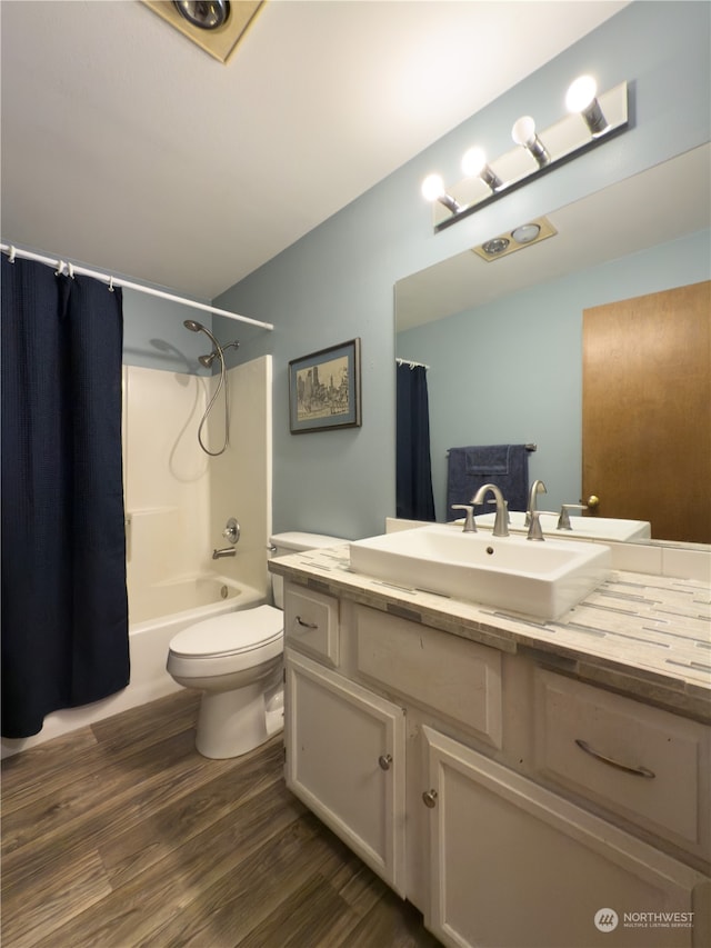 full bathroom featuring hardwood / wood-style floors, toilet, shower / bathtub combination with curtain, and vanity