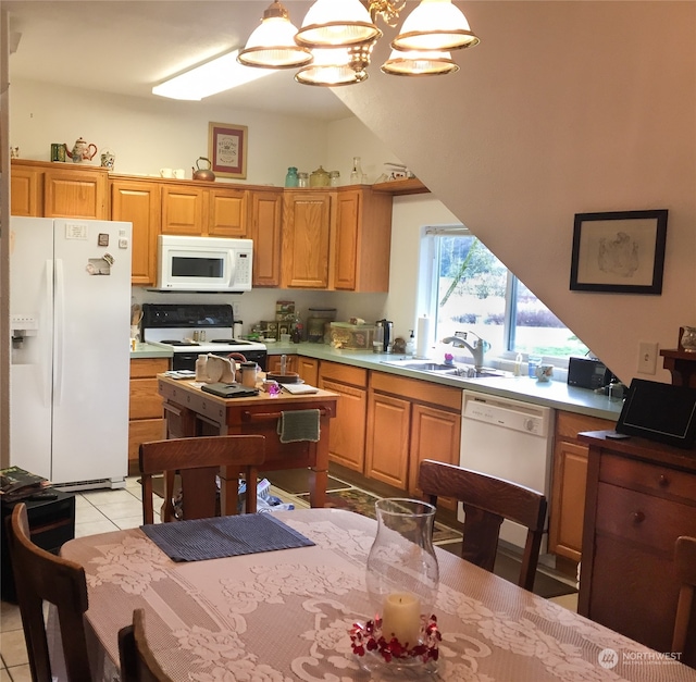 kitchen with sink, a chandelier, pendant lighting, white appliances, and light tile patterned flooring